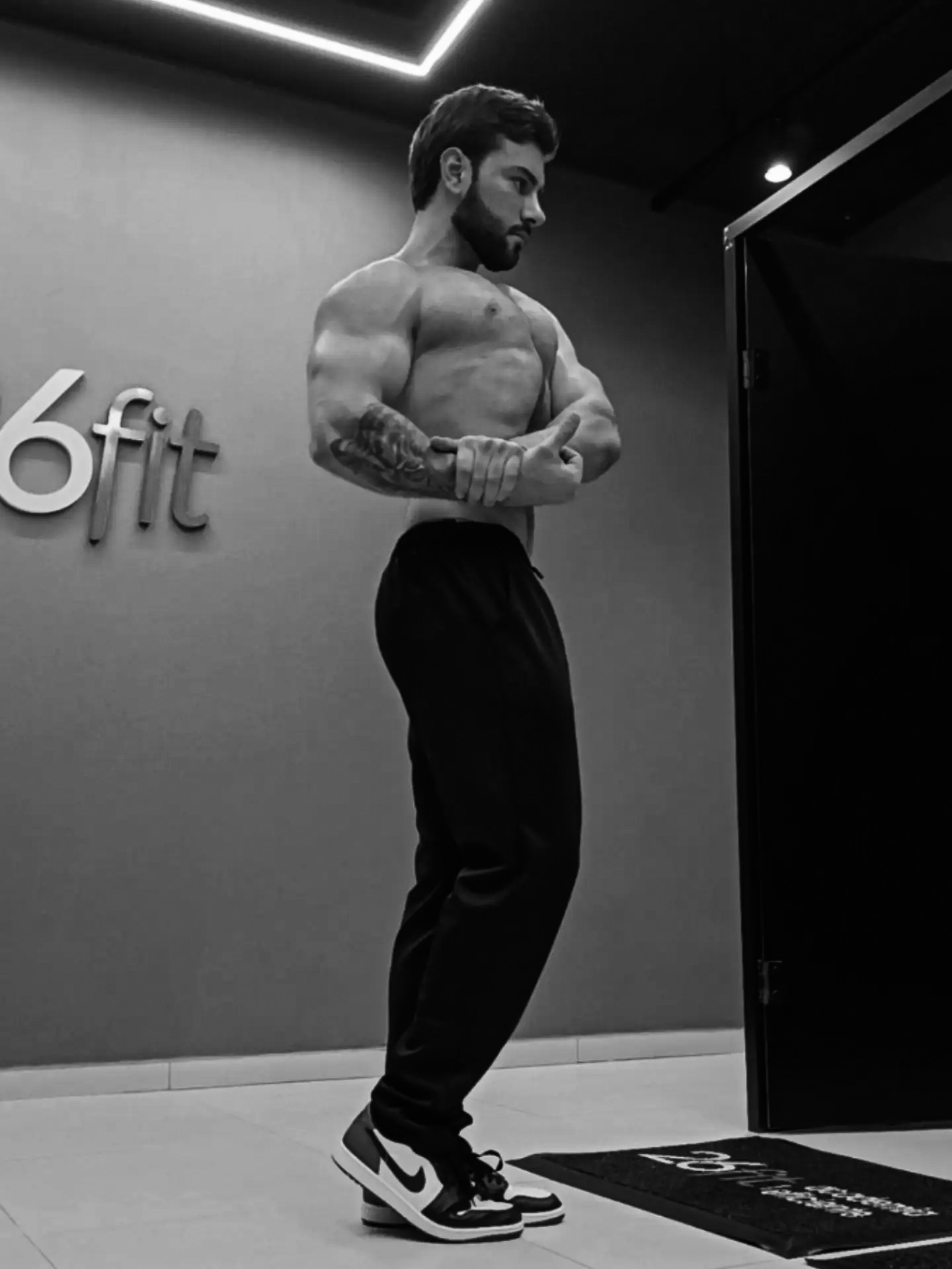 LF Team — treinador em pose de peito lateral na academia, foto em preto e branco